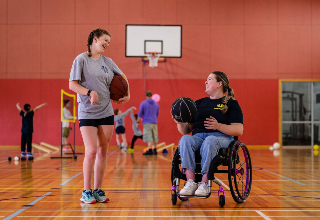 Image of two girls playing basketball one is in a wheelchair
